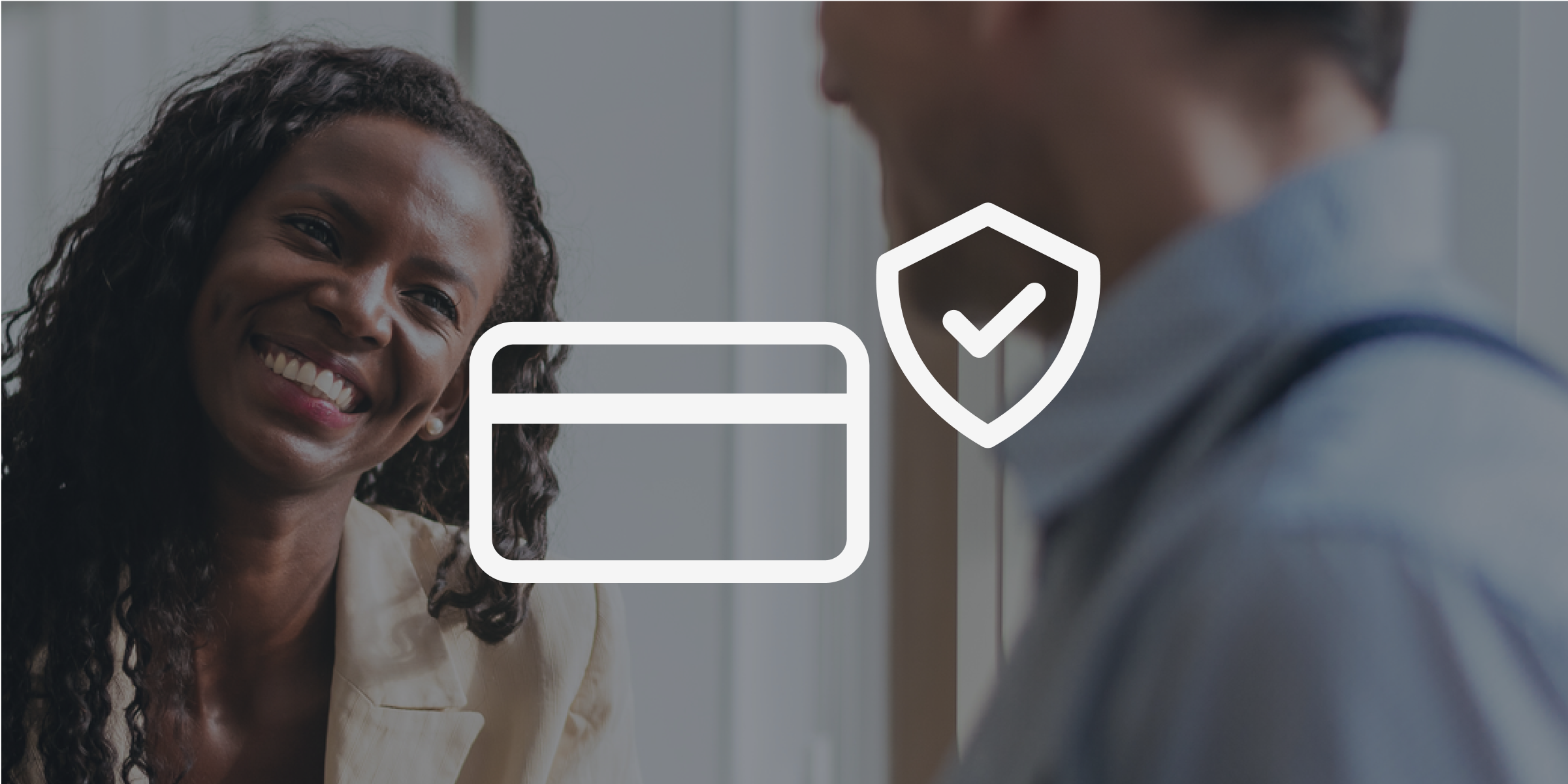 A black woman smiling at a man. His back is to the camera. There is a white credit card and checkmark icon on the image.